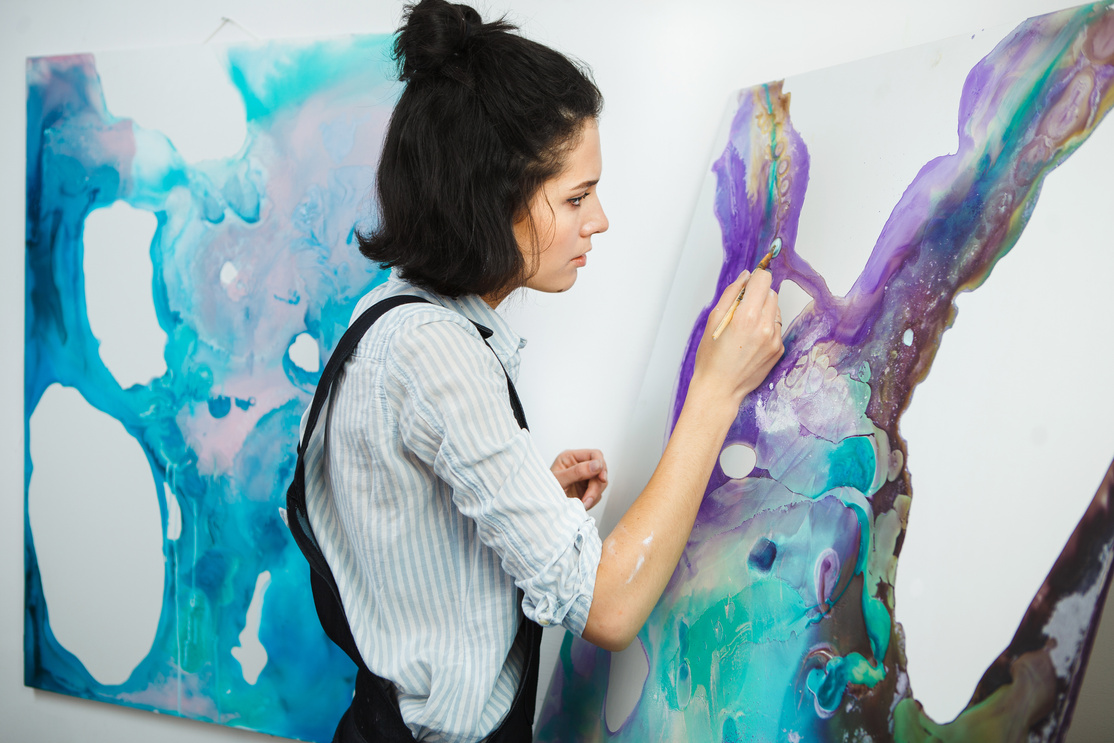 Concentrated woman focused on creative art-making process in art therapy