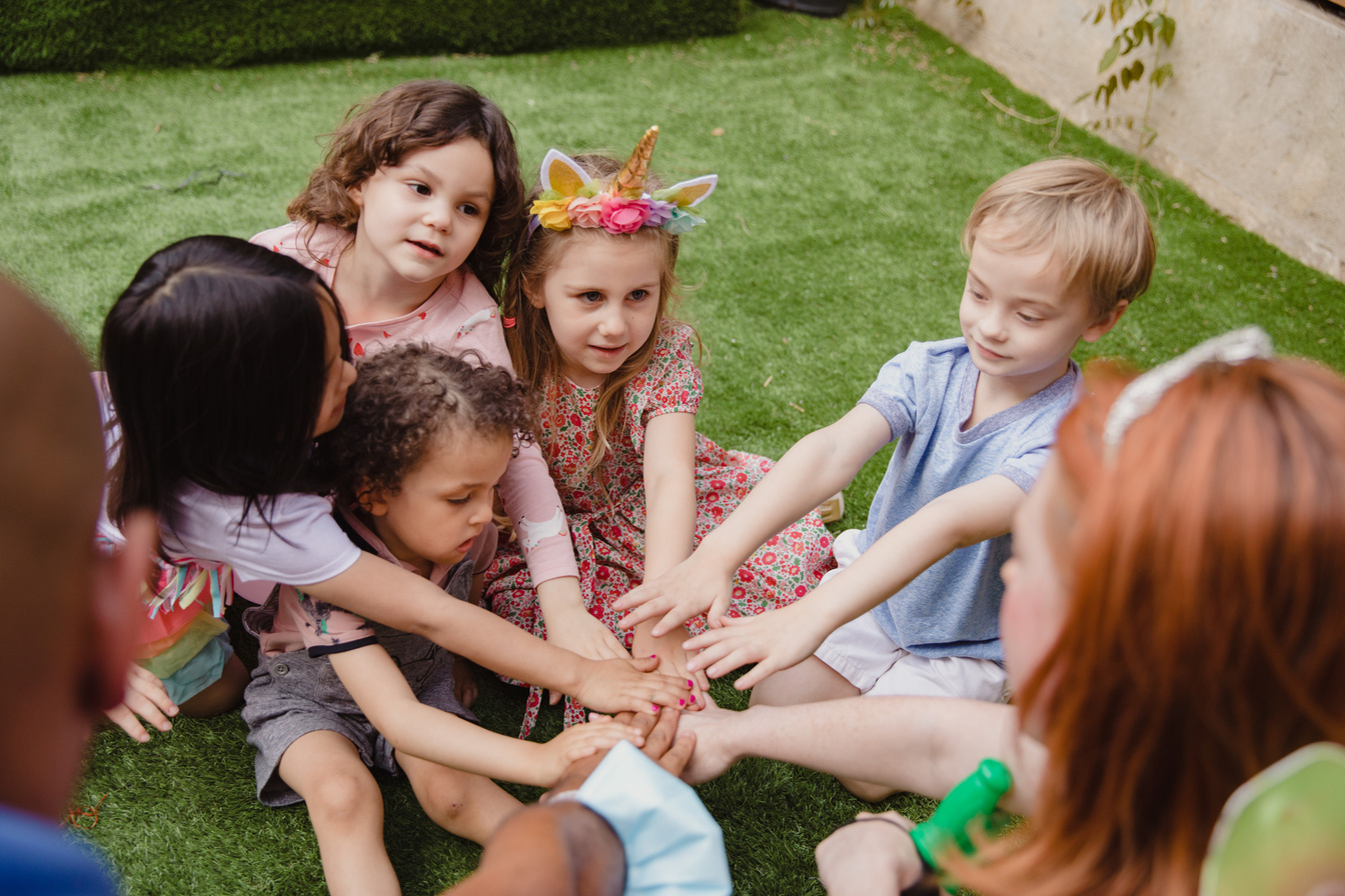 Children Sitting on Green Grass